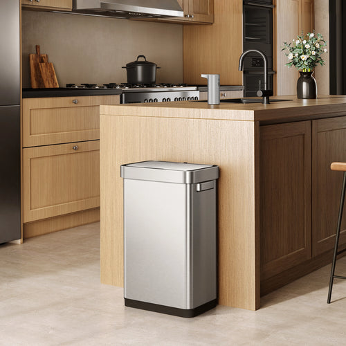 EKO trash can next to a modern kitchen counter, surrounded by light wood cabinetry and appliances.