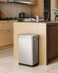 EKO trash can next to a modern kitchen counter, surrounded by light wood cabinetry and appliances.