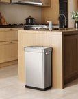 EKO trash can next to a modern kitchen counter, surrounded by light wood cabinetry and appliances.