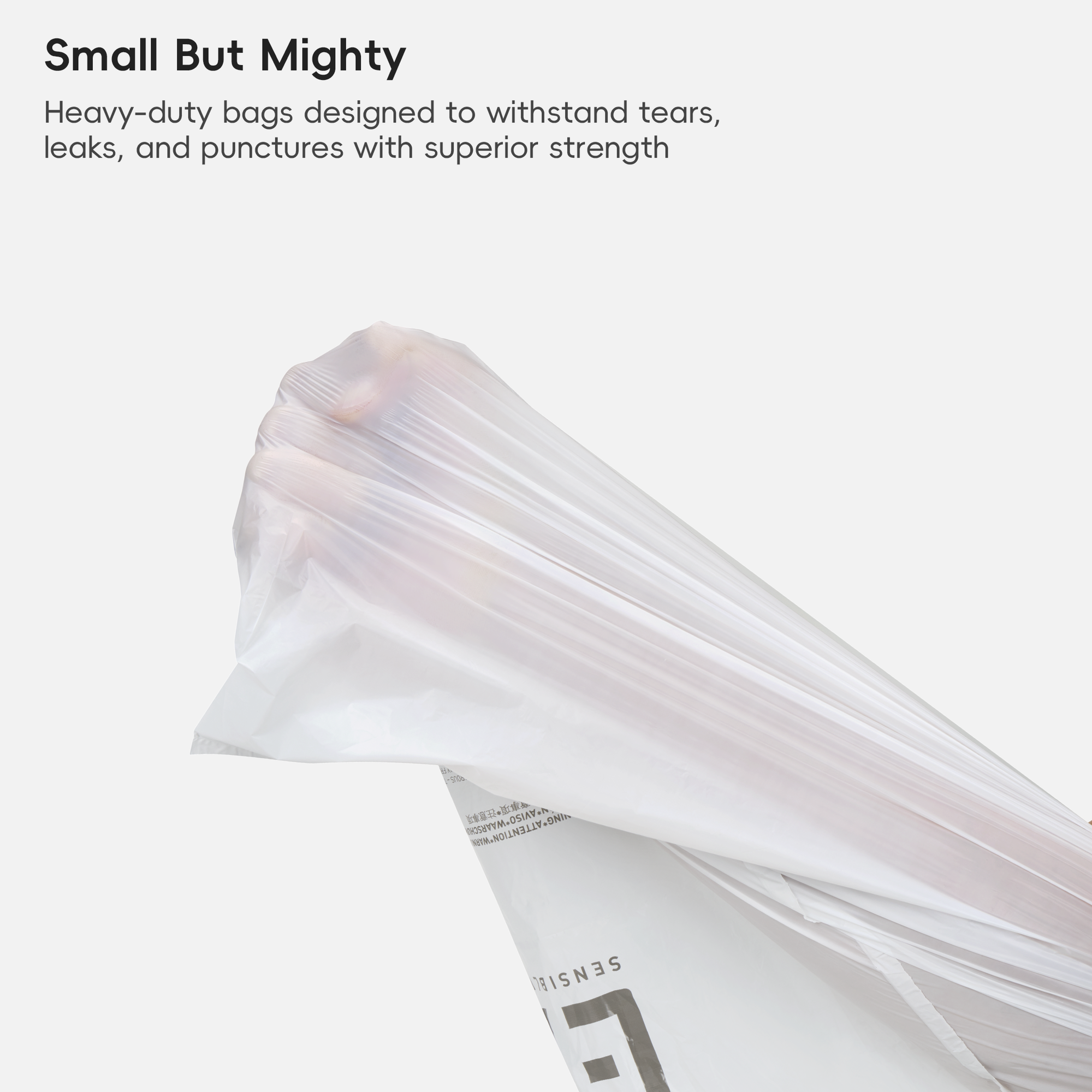A stack of clear, heavy-duty plastic bags lies on a white background. The image displays text reading: "Small But Mighty. Heavy-duty bags designed to withstand tears, leaks, and punctures with superior strength."