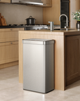 EKO trash can next to a modern kitchen counter, surrounded by light wood cabinetry and appliances.
